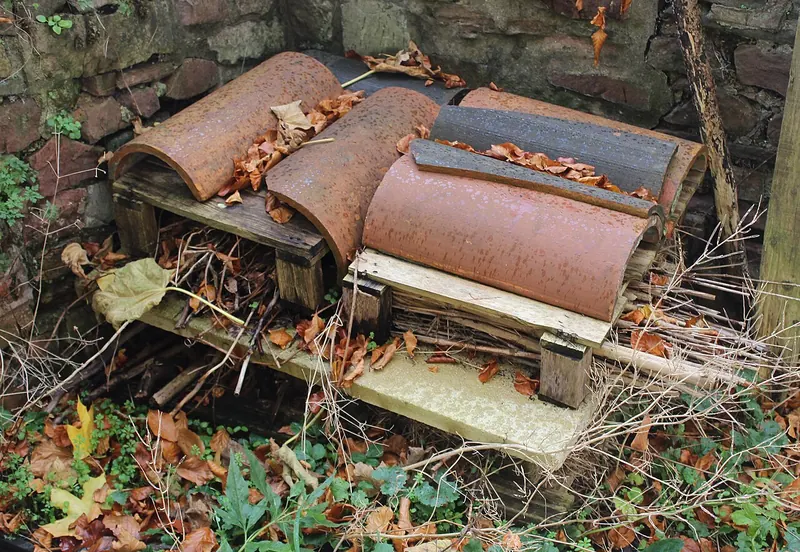 A wooden insect hotel and hedgehog house in a Bristol community garden